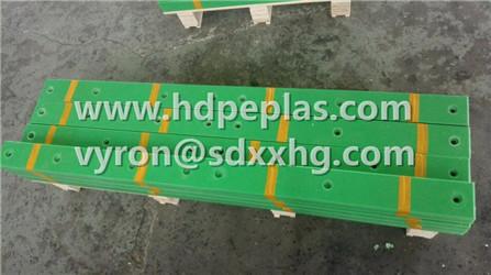 Green HDPE wear resistant strips with holes.